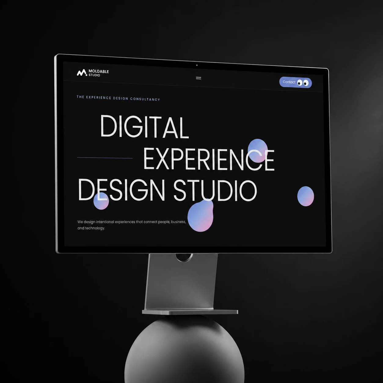 Moldable website on a monitor, with the headline “Digital Experience Design Studio” and floating gradient shapes.
